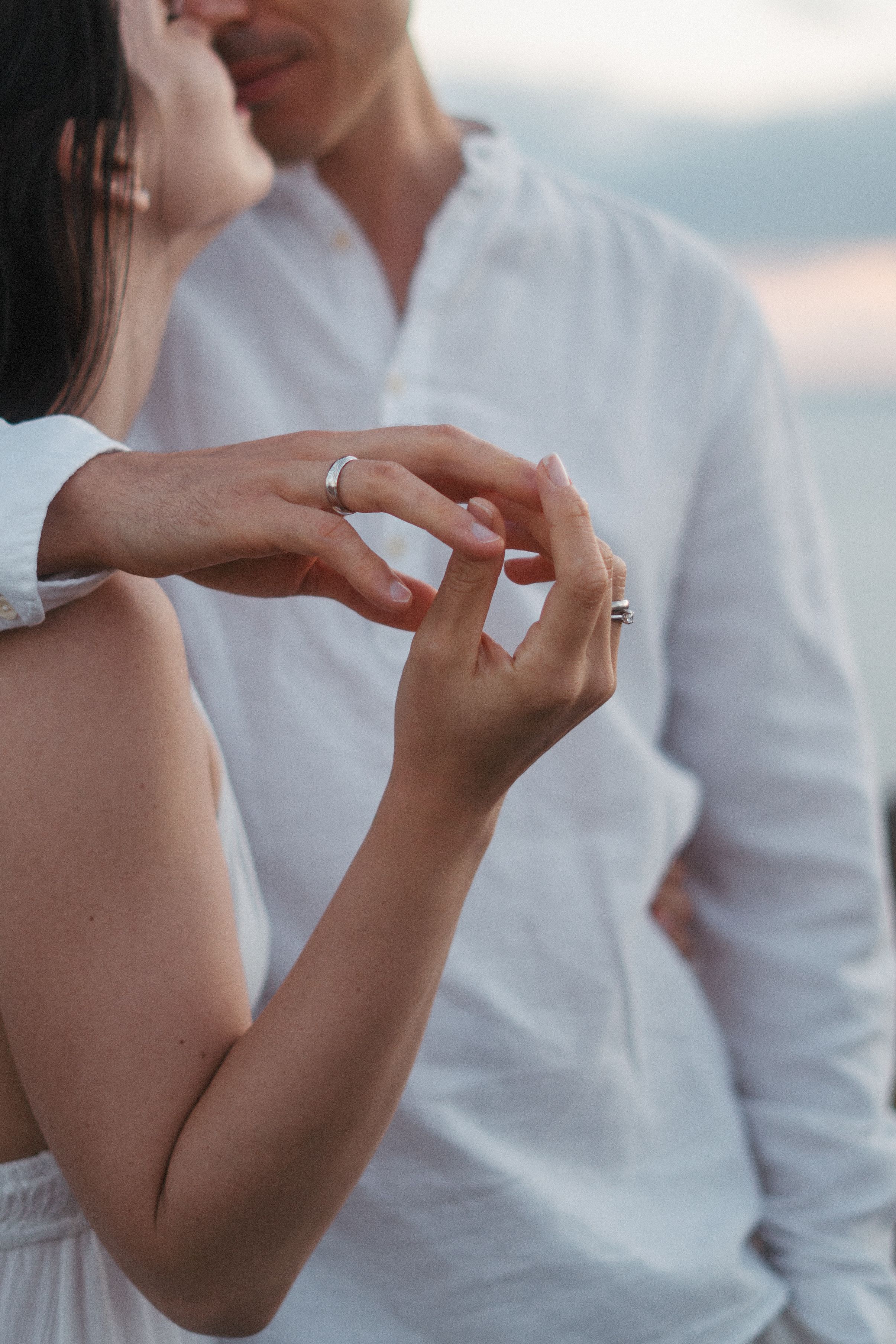 Couple looking at wedding rings by the ocean